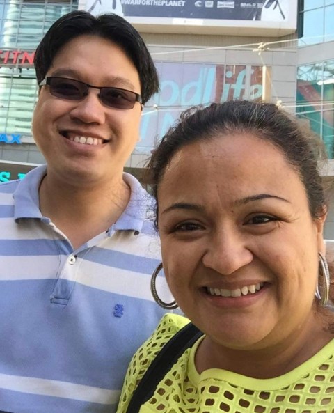 Male wearing blue with sunglasses and big smile and woman wearing yellow also with big smile.